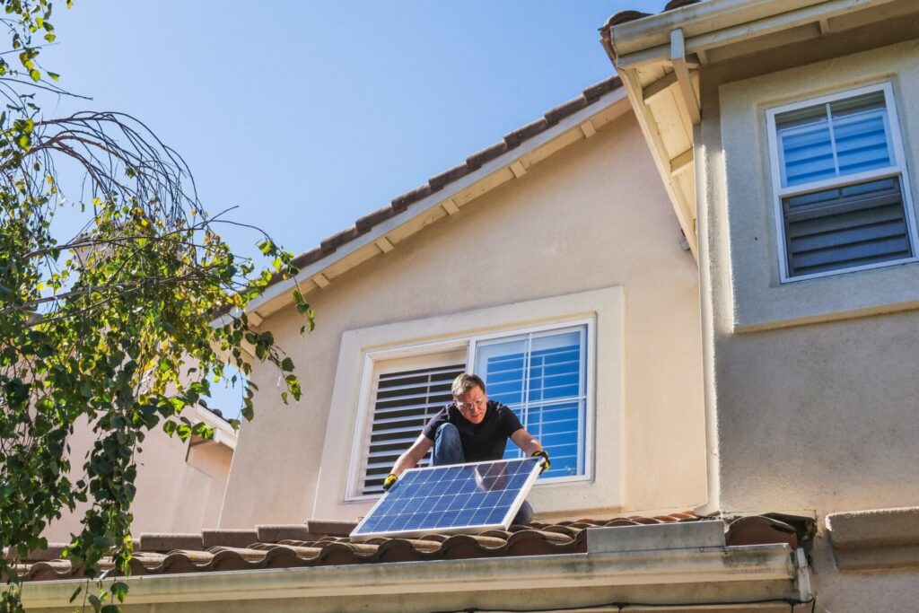 Ein Mann der eine Solaranlage auf einem Dach installiert