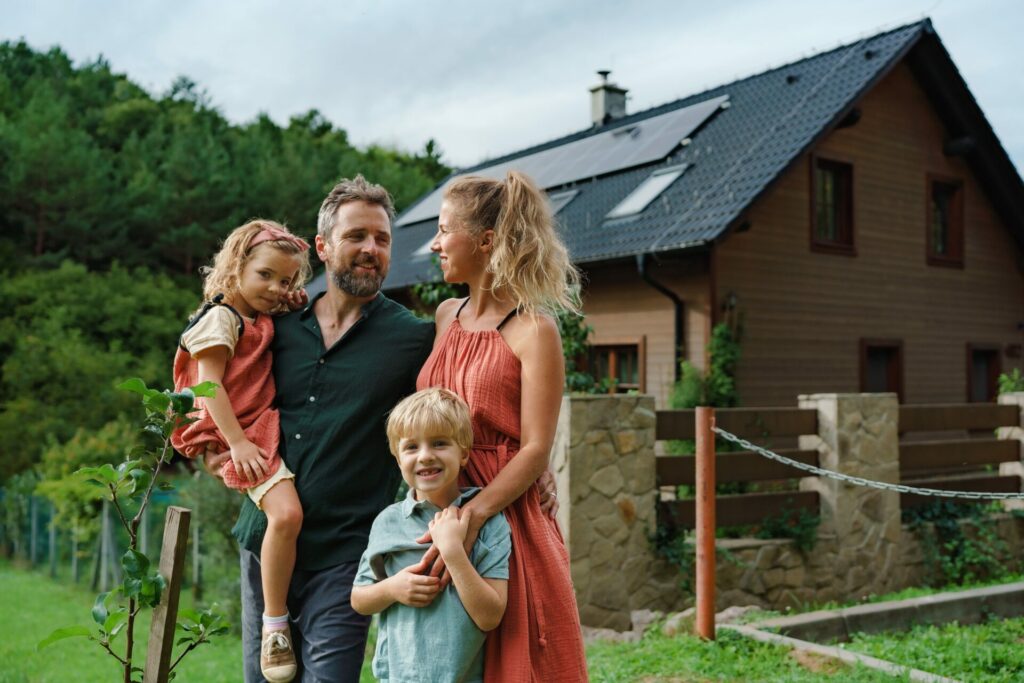 Mutter Vater Sohn und Tochter vor dem Eigenheim